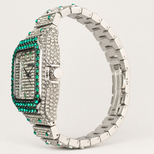 Side view of a silver-tone square watch with green border accents and segmented bracelet