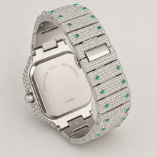 Rear view of a silver-tone square watch with green border accents and open bracelet