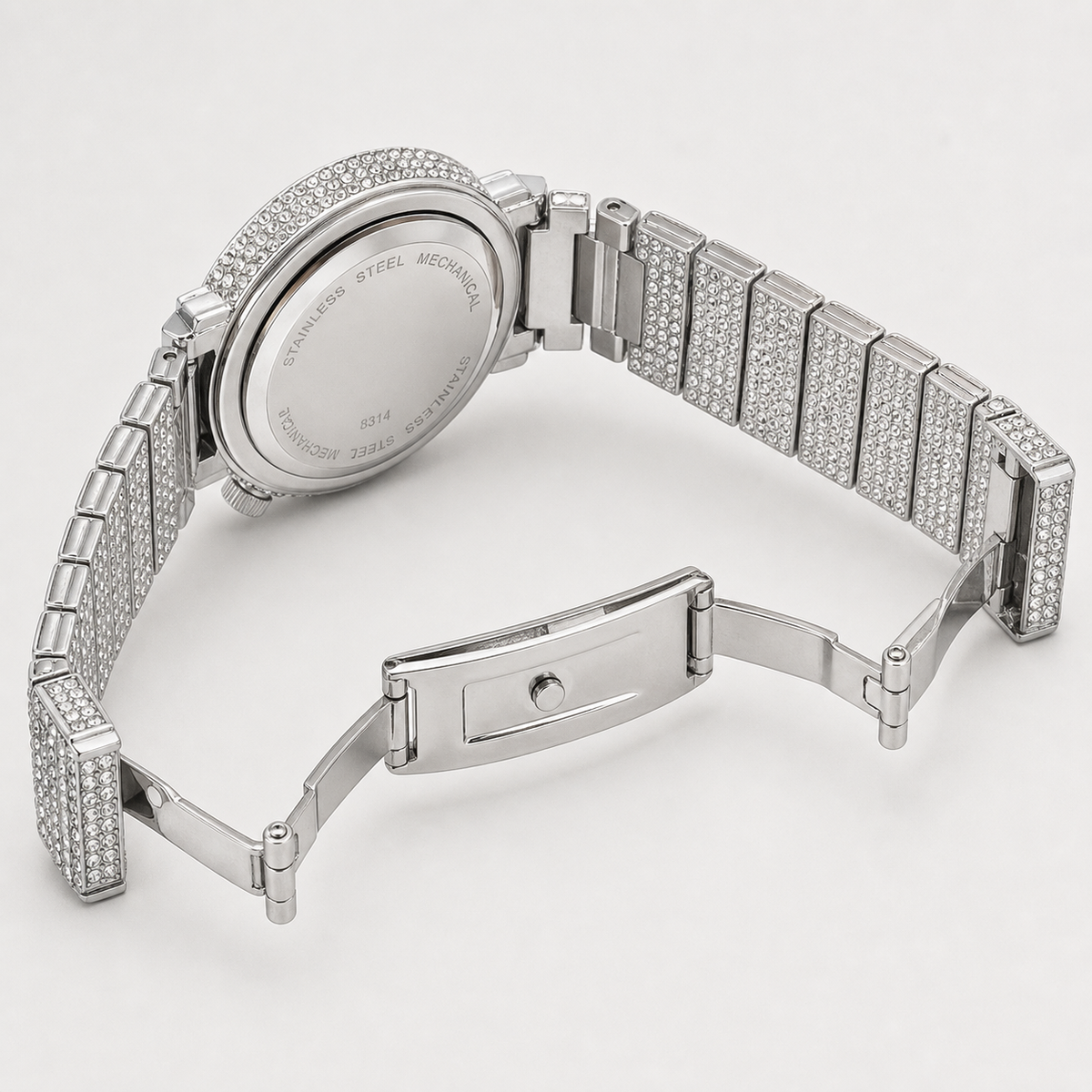 Silver-tone crystal-set watch with open deployant clasp and caseback engraved “STAINLESS STEEL MECHANICAL”