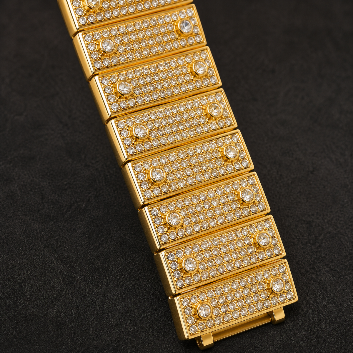 Gold-tone crystal-set watch bracelet with rectangular pavé links, close-up view